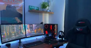 Gaming-Stuhl vor einem Schreibtisch mit Bildschirmen und beleuchteter Tastatur.